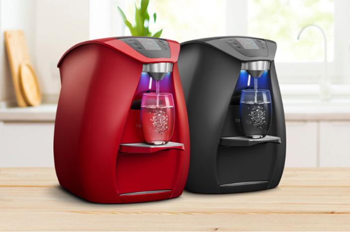 Red and black water filter machines on counter.