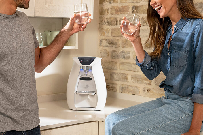 Couple enjoying drinks by home water dispenser