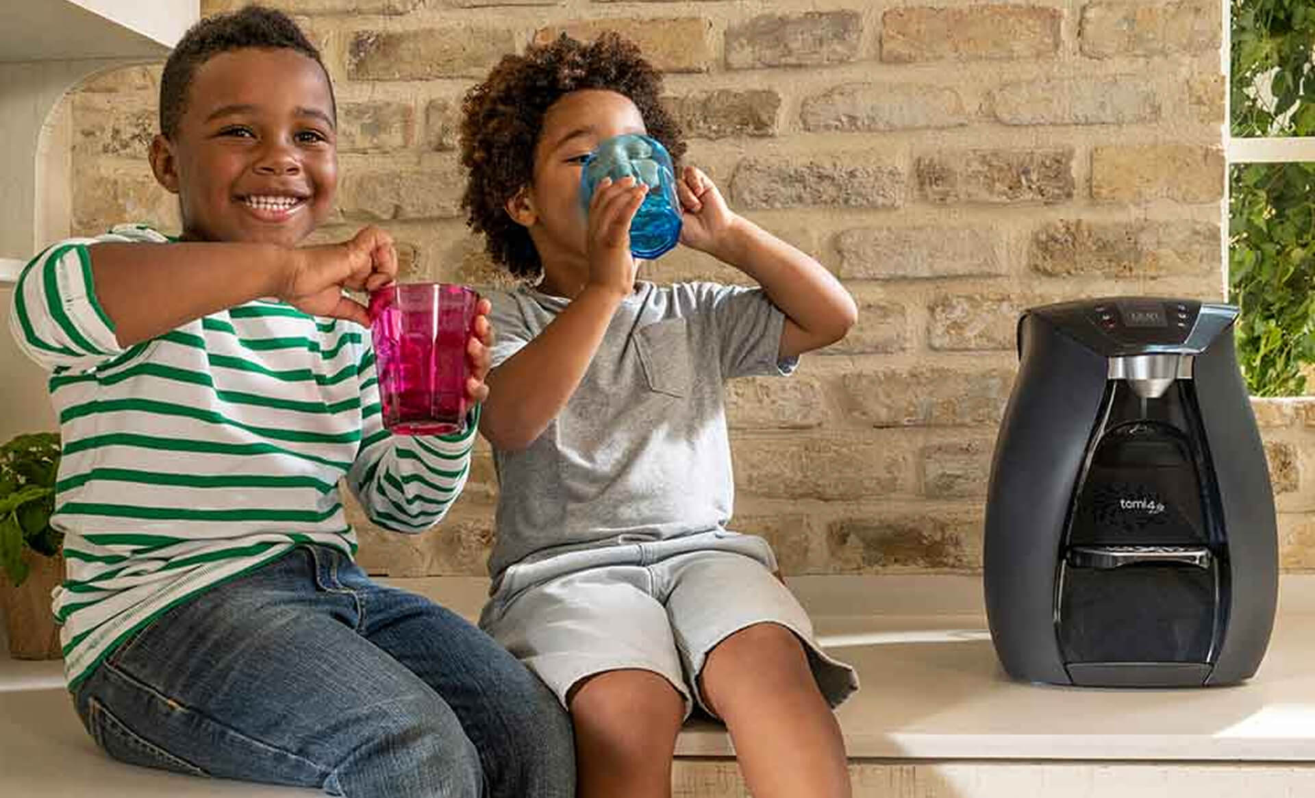 Two kids drinking near water purifier