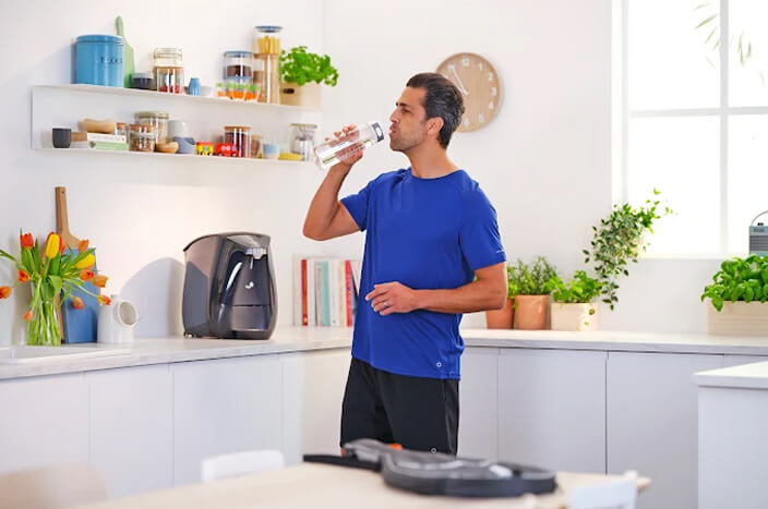 Man drinking water in modern kitchen