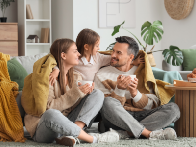 Οικογένεια χαλαρώνει στο σαλόνι με καφέ.