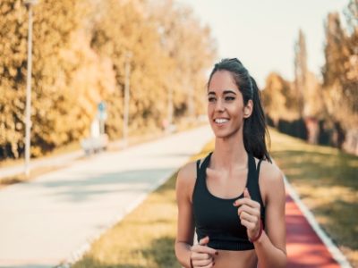 Young woman jogging in morning looking over shoulder.