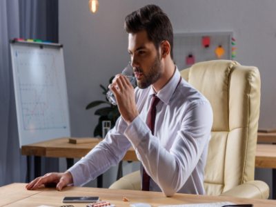 handsome businessman drinking water in office